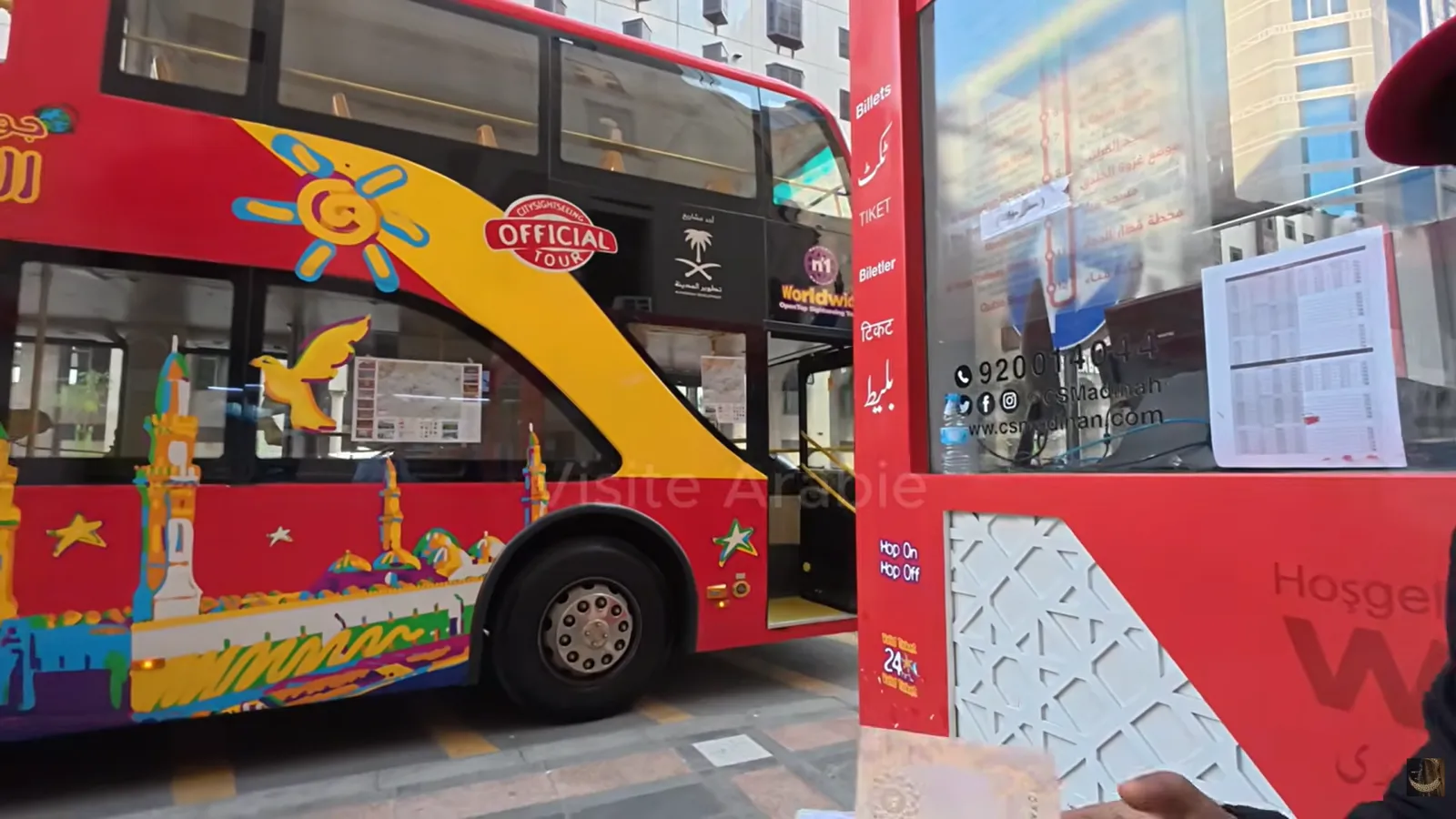 Le bus rouge à deux étages et le comptoir des tickets, près de la porte 334 de la mosquée du Prophète